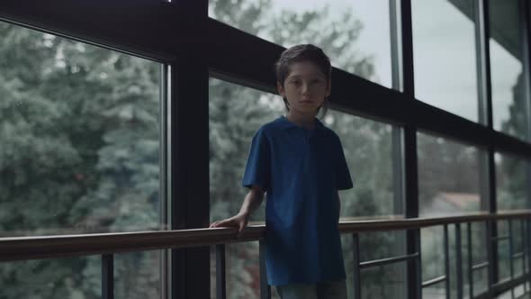 Sad Boy Standing Alone at Panorama Window