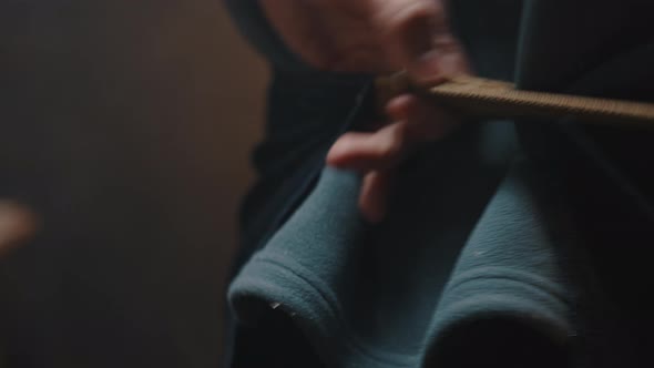 Closeup of the Carpenters Male Hands Fastening the Strap From the Work Apron Behind His Back