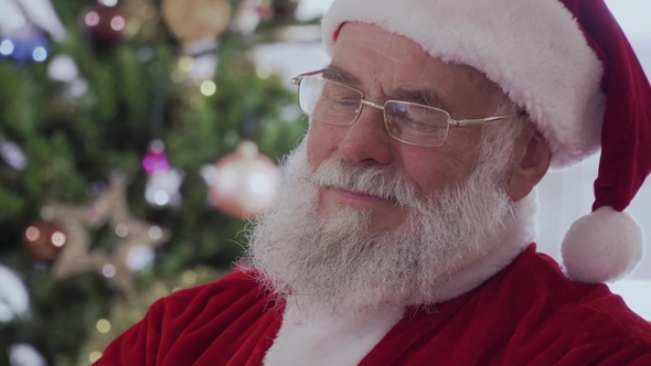 Santa Claus Sitting and Laughing While Reading a Funny Book