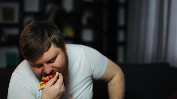 Weak-willed Overweight Man Eating Pizza and Drinking Beer Sitting on the Couch