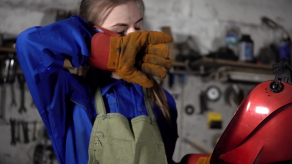 Cute Welder Girl in Uniform in the Garage Working with Welding Equipment. Women's Work in Art