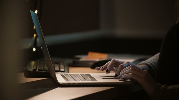Woman Working with a Laptop at Night Female Hands Using Notebook Touchbar and Trackpad