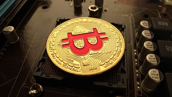 Gold Bit Coin BTC Coins on the Motherboard. Bitcoin Is a Worldwide Cryptocurrency