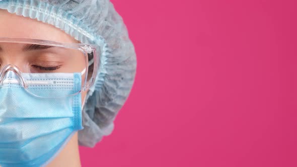 Half Face of a Doctor in a Blue Medical Coat Safety Glasses and Medical Cap Looking Forward