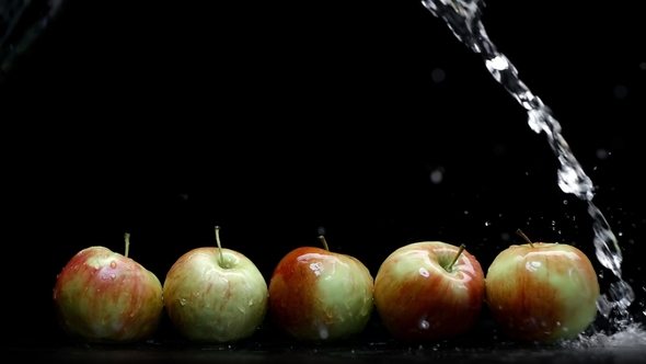 Red and Yellow Apples Wash Under Water Splash with Lot of Droplets on Black Background