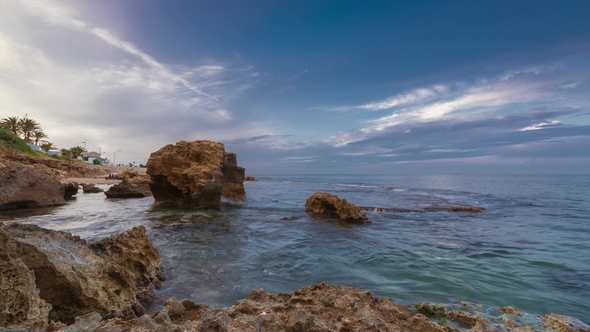 Sunset on the Beach Among the Rocks Near the City of Denia