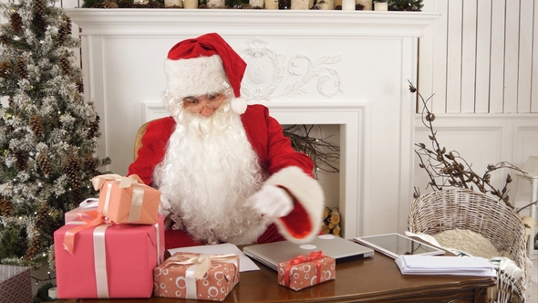 Santa Claus in His Christmas Workshop Signing Presents for Children