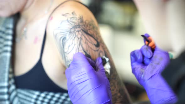 Tattoo artist tattooing an arm