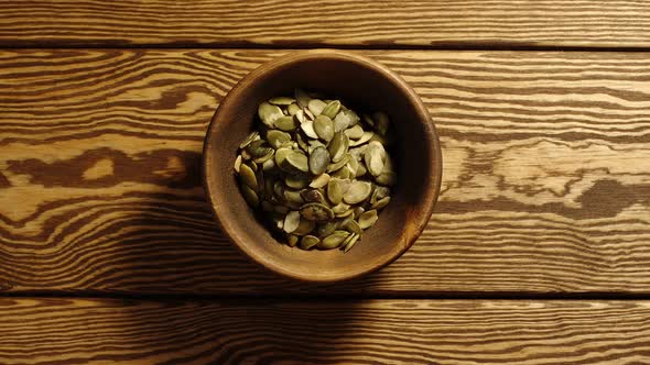 Peeled pumpkin seeds appear in wooden cup and full this cup