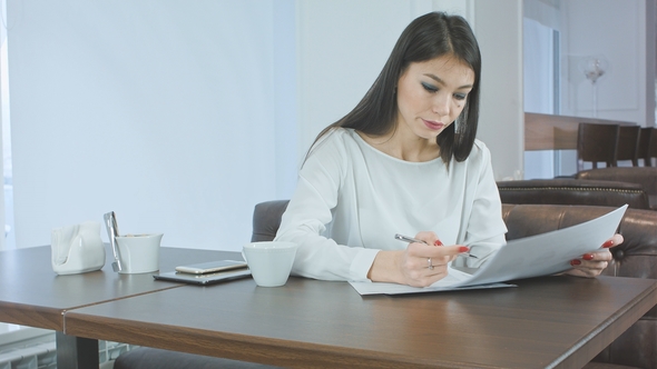 Young Busy Woman Preparing Project Report Sitting in the Cafe