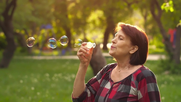 Mature Woman Blowing Bubbles