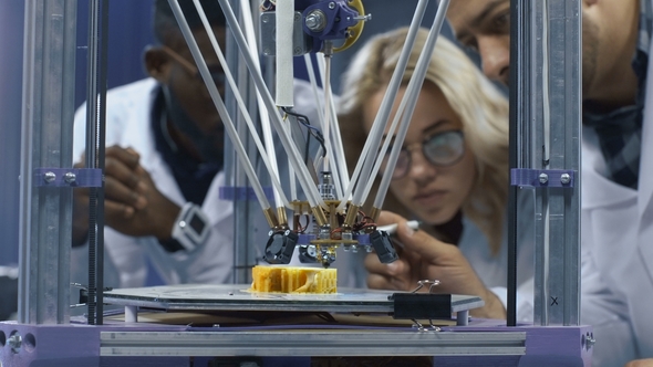 Researchers Watching 3-D Printing Machine in Process