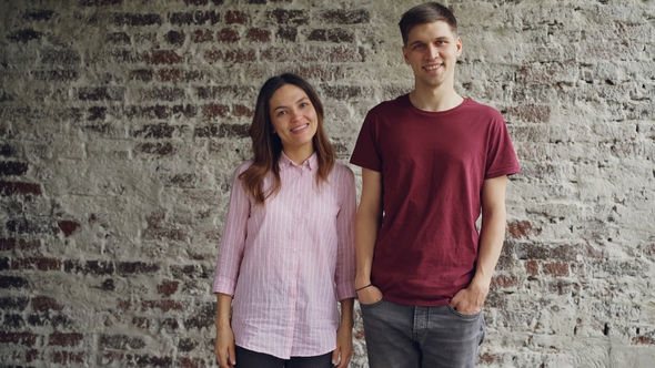 Portrait of Mixed Race Couple Standing Together Against Brick Wall