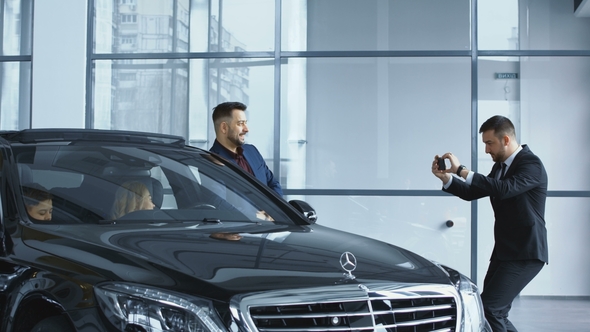 Dealer Taking Picture of Family in New Car