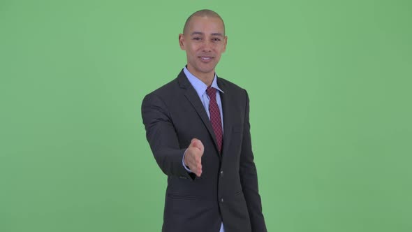 Happy Bald Multi Ethnic Businessman Giving Handshake