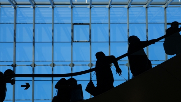 The Glass Window Airport Escalator with Moving Silhouette of People