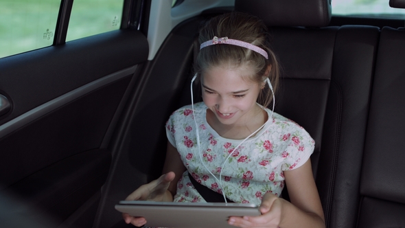 Child Playing Online Game with Tablet Pc in Car