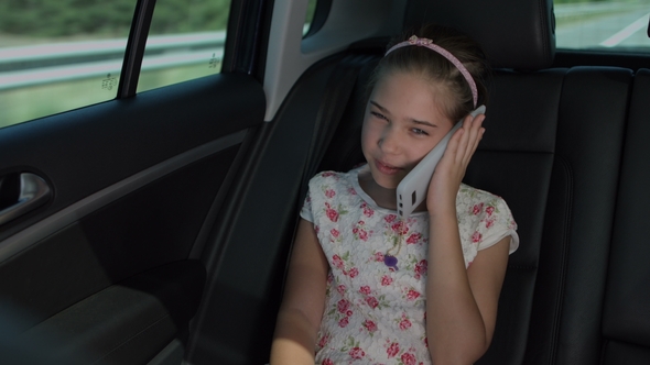 Adorable Girl Talking on Cellphone in Luxury Car