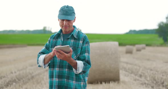 Farmer Using Digital Tablet While Examining Farm