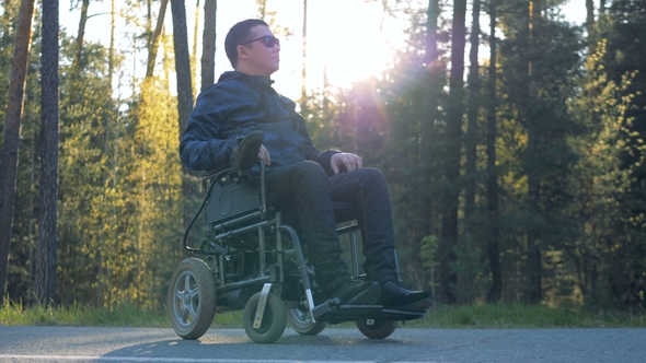 One Man Sits Outdoors in a Wheelchair