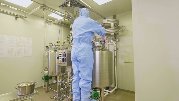 Employee Opens Cover Rotating Valves in Laboratory