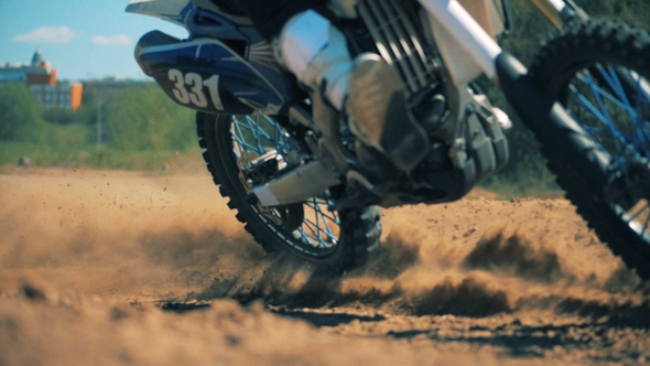 Clouds of Sand Getting Raised By a Moving Motorcycle