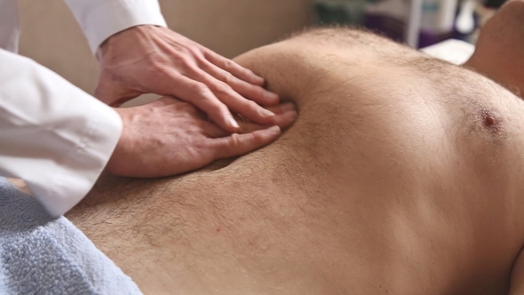 Massagist Making Abdominal Massage for Man in the Clinic