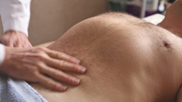 Massagist Making Abdominal Massage for Man in the Clinic