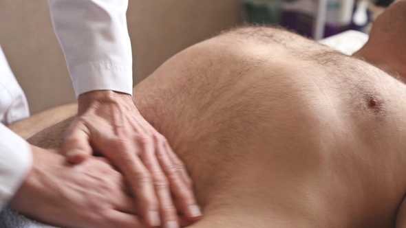 Massagist Making Abdominal Massage for Man in the Clinic