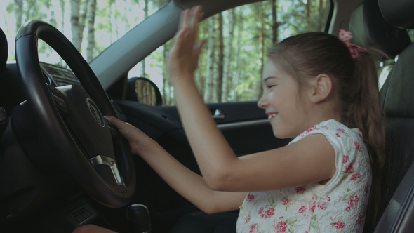 Cheerful Girl Pressing Car Horn on Steering Wheel