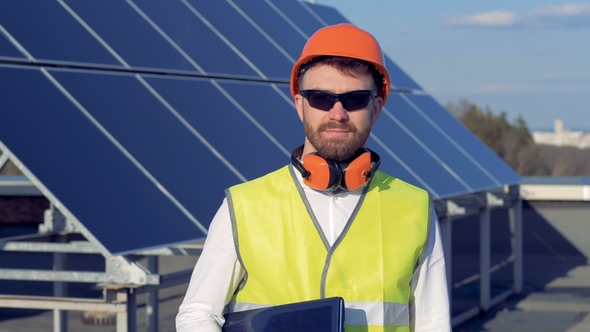 Male Engineer Is Standing Against the Background of a Solar Elements