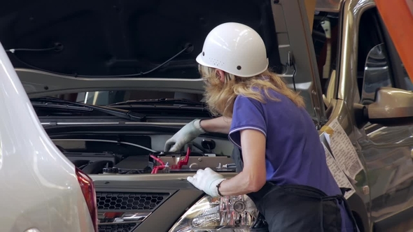 Worker Woman Is Tightening Caps of Capacities for Technical Liquids Inside a Car on a Car Factory