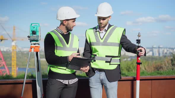 Foreman and Worker Arguing on Construction Site Analyzing Project Paperwork