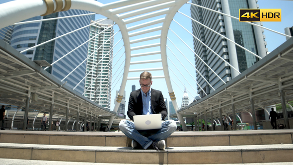 Developer Working On Laptop At Street