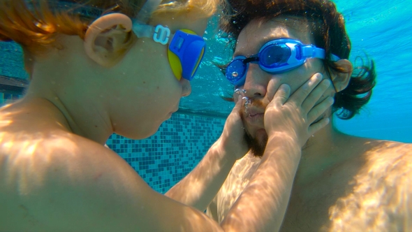 Underwater Shot of Father and His Toddler Son Swining Diving and Having Fun in a Pool