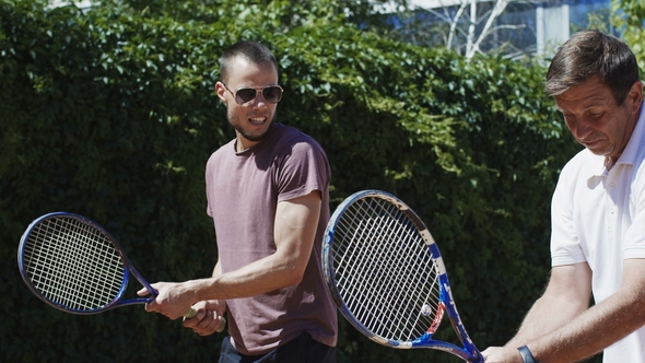 Trainer Showing Racket Position To Man