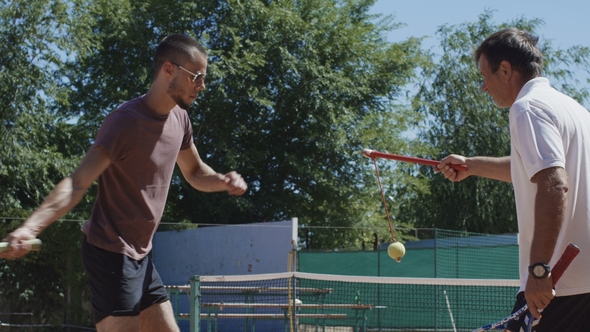 Tennis Trainer Working with Man on Court