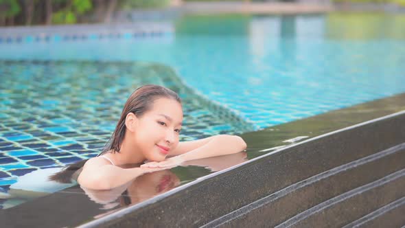 Young asian woman enjoy around outdoor swimming pool for leisure