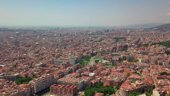 Flying Over Barcelona at Sunset, Spain. Streets and Houses in Warm Light of Evening Sun