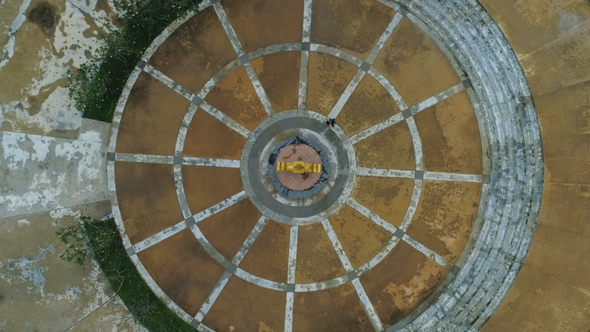 Aerial: A Girl Walking Around Circle Monument Clockwise