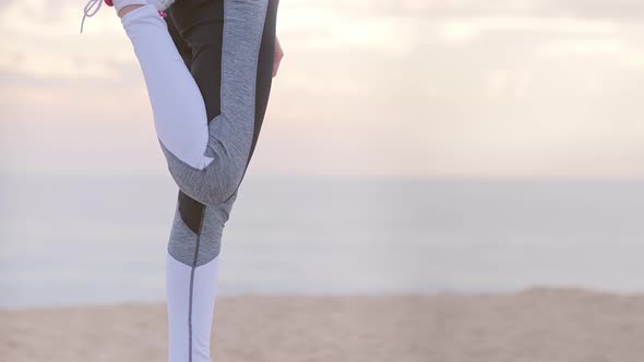 Active Woman Jogger on the Seashore Doing Stretching Exercises
