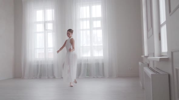 Ballet Dancer in a Snow-white Dress Beautifully Dances and Spins on Tiptoe