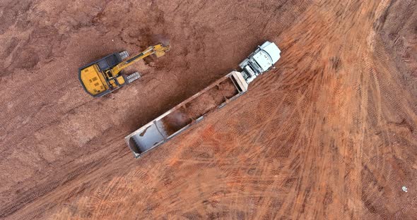 Work on Construction Site with Excavator Loading Soil Into Dump Trucks