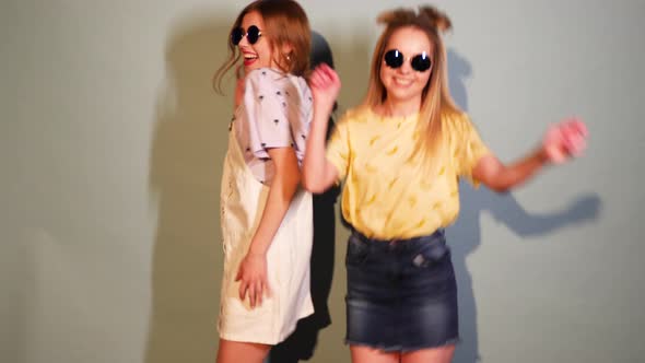 Two Carefree Young Girls Going Crazy. Women in hipster summer clothes having fun and dancing