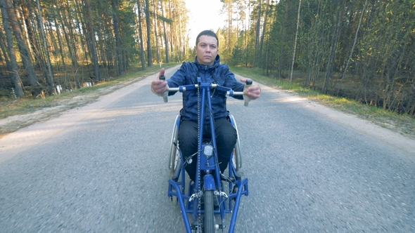Front View of a Handicapped Man Training His Arms in a Special Wheelchair