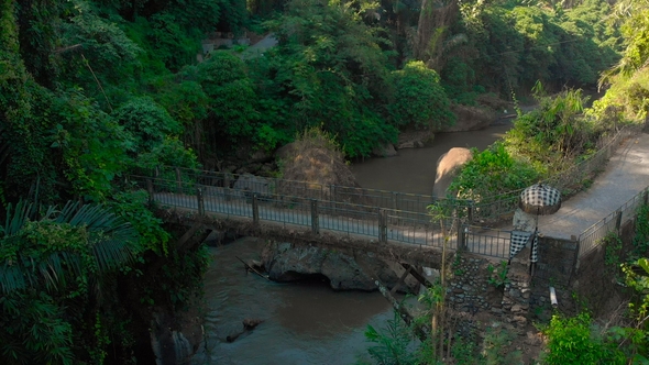 Aerial Shot of a Small Bridge Over the River with a Small Local Temple on It in Bali, Indonesia