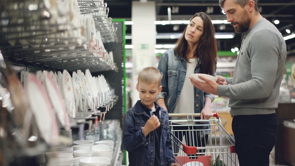 Smiling Family Is Buying Bowls and Plates in Kitchenware Department in Hypermarket, They Are Taking