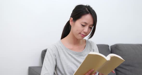 Woman Reading Book on Sofa