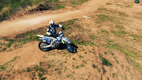 Panoramic View of a Motorcyclist with His Bike on a Hill