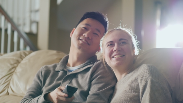 Morning Watching TV Together. Young Couple Sitting on the Couch, Having a Good Time Together